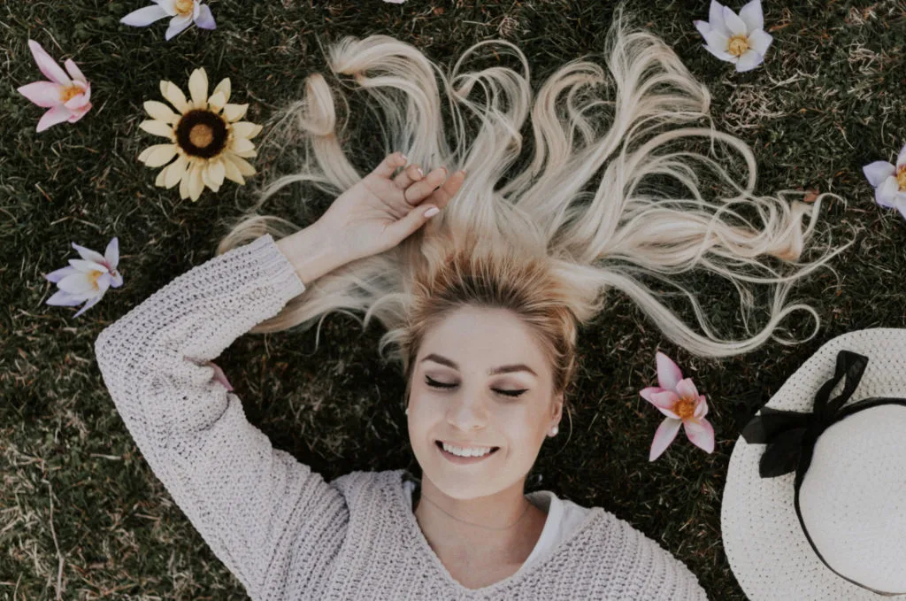 smiling girl on the grass with flowers