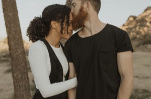 man kissing girlfriend on forehead