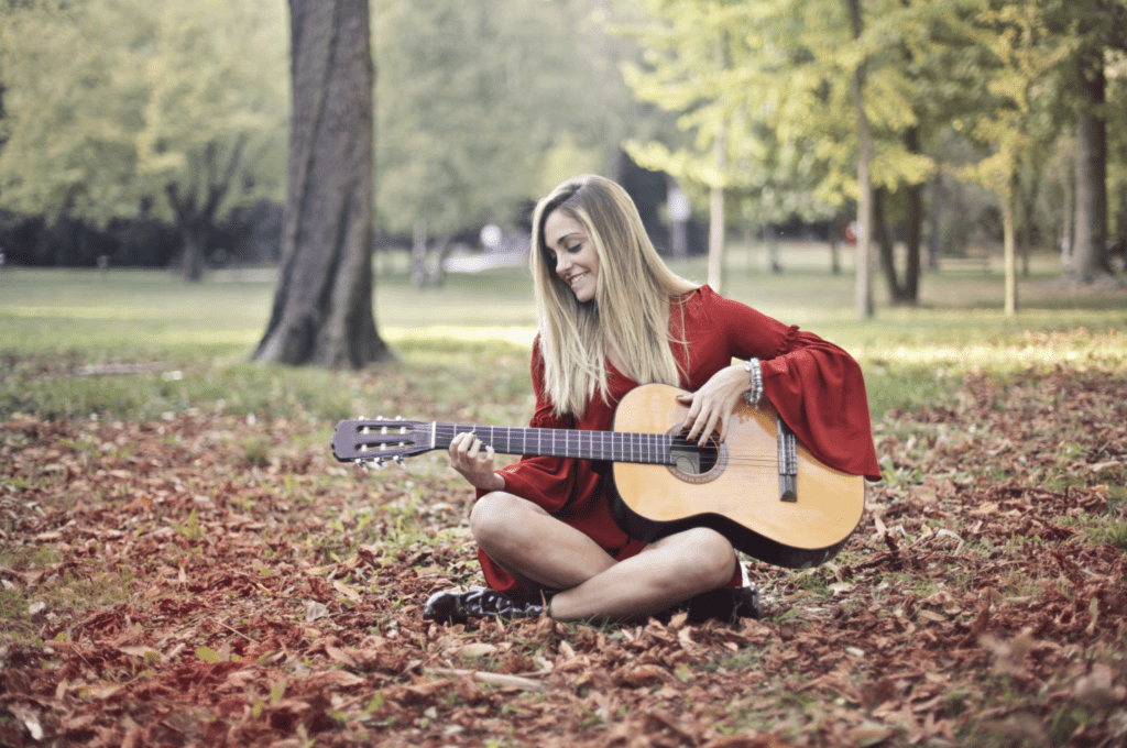 girl playing guitar in forest