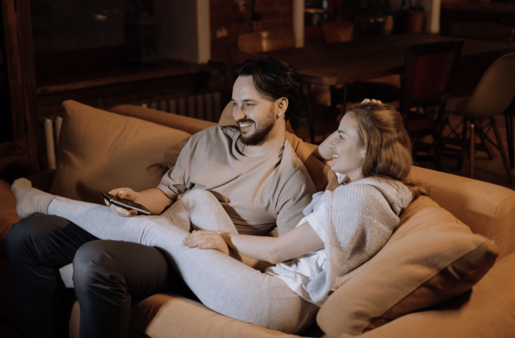 couple watching tv in sofa