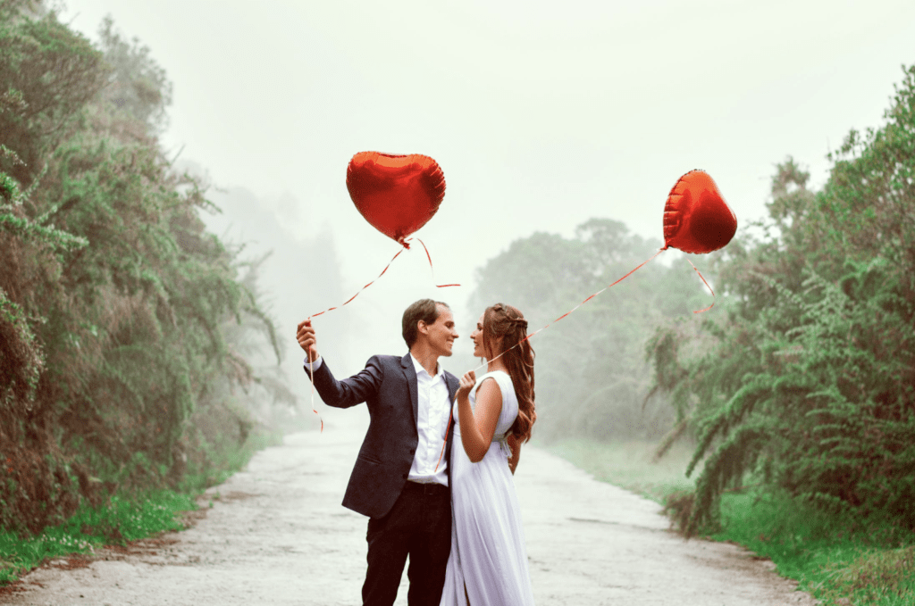 couple holding heart-shaped balloons