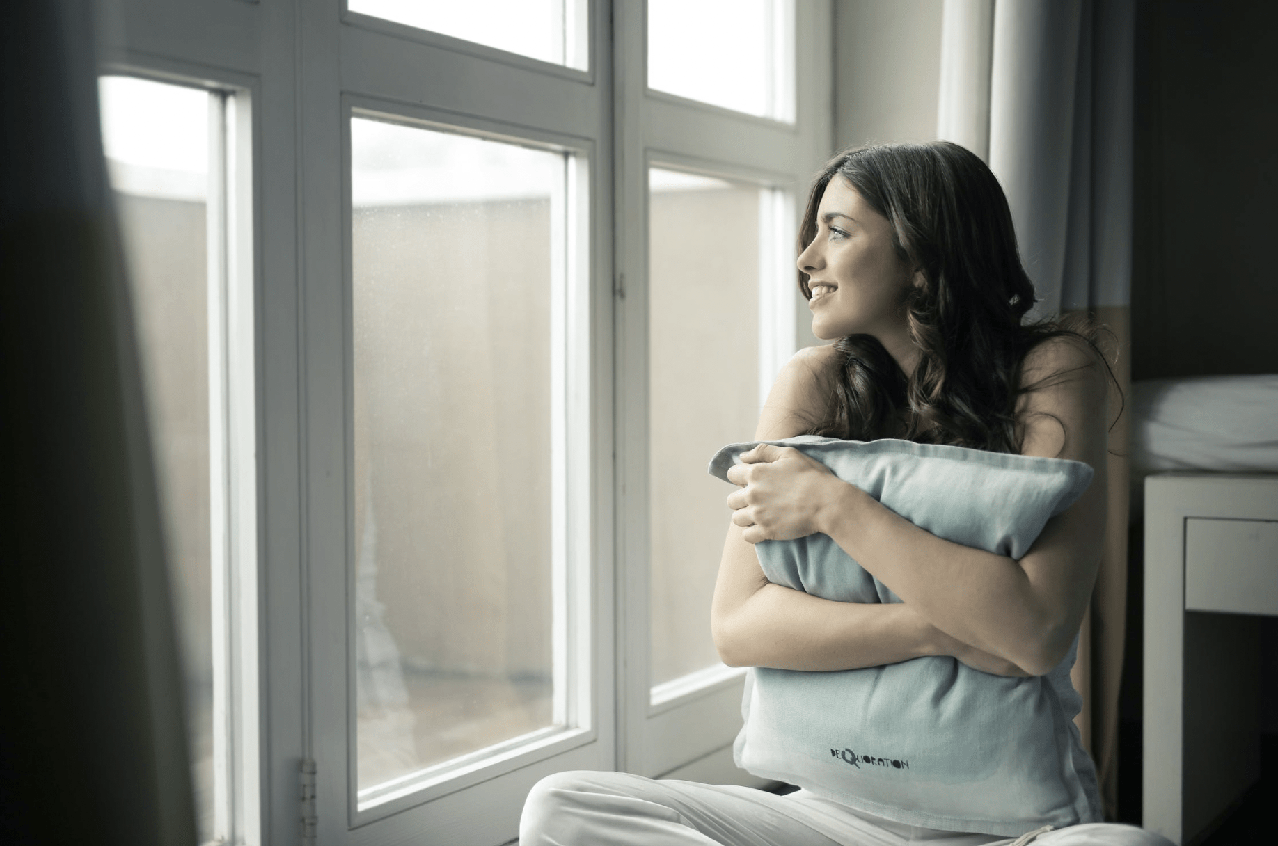 woman smiling while staring out the window