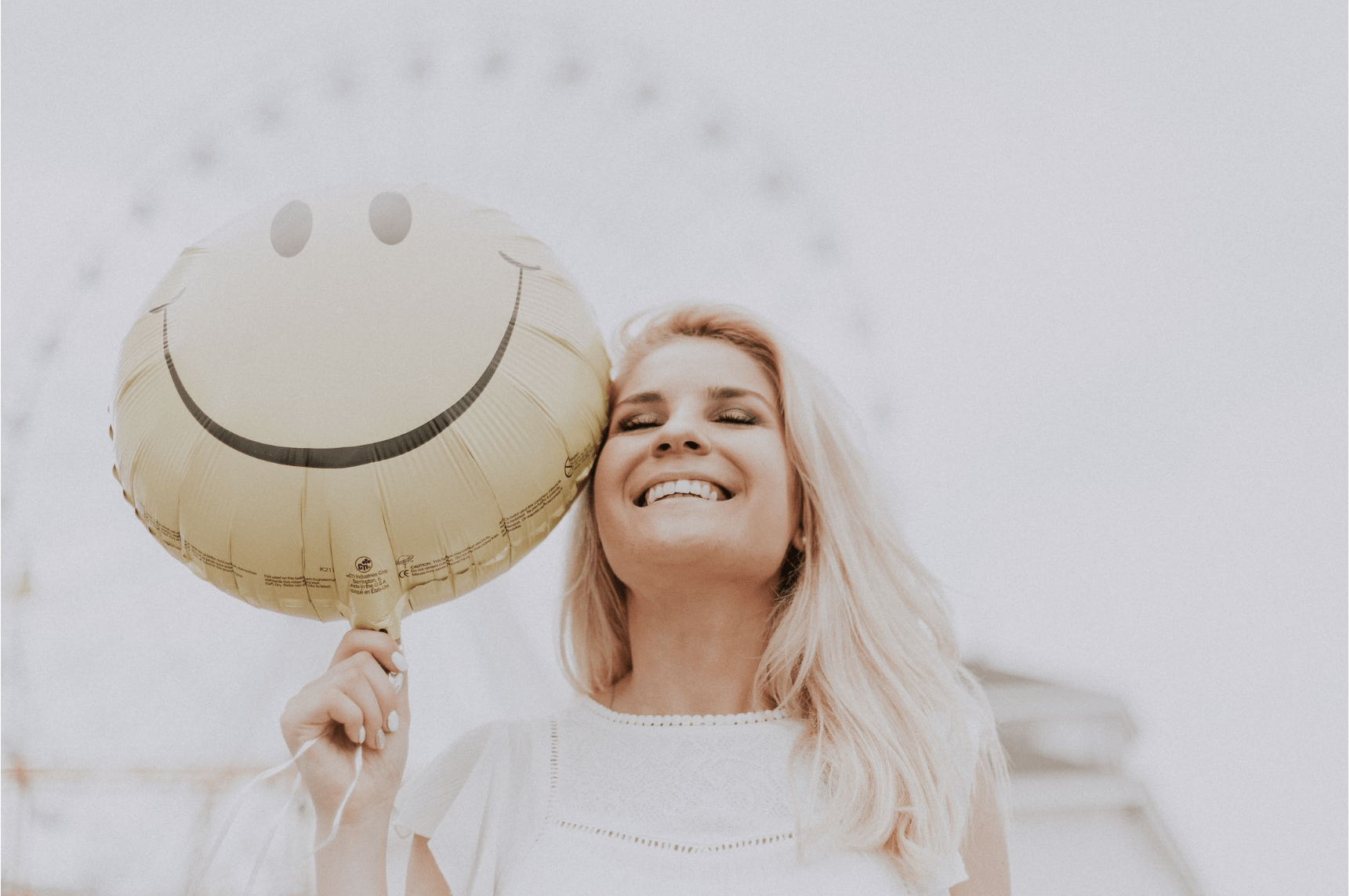 woman smiling with a smiley balloon