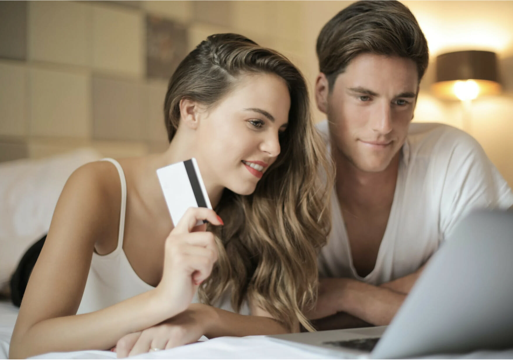 couple in bed looking at laptop 