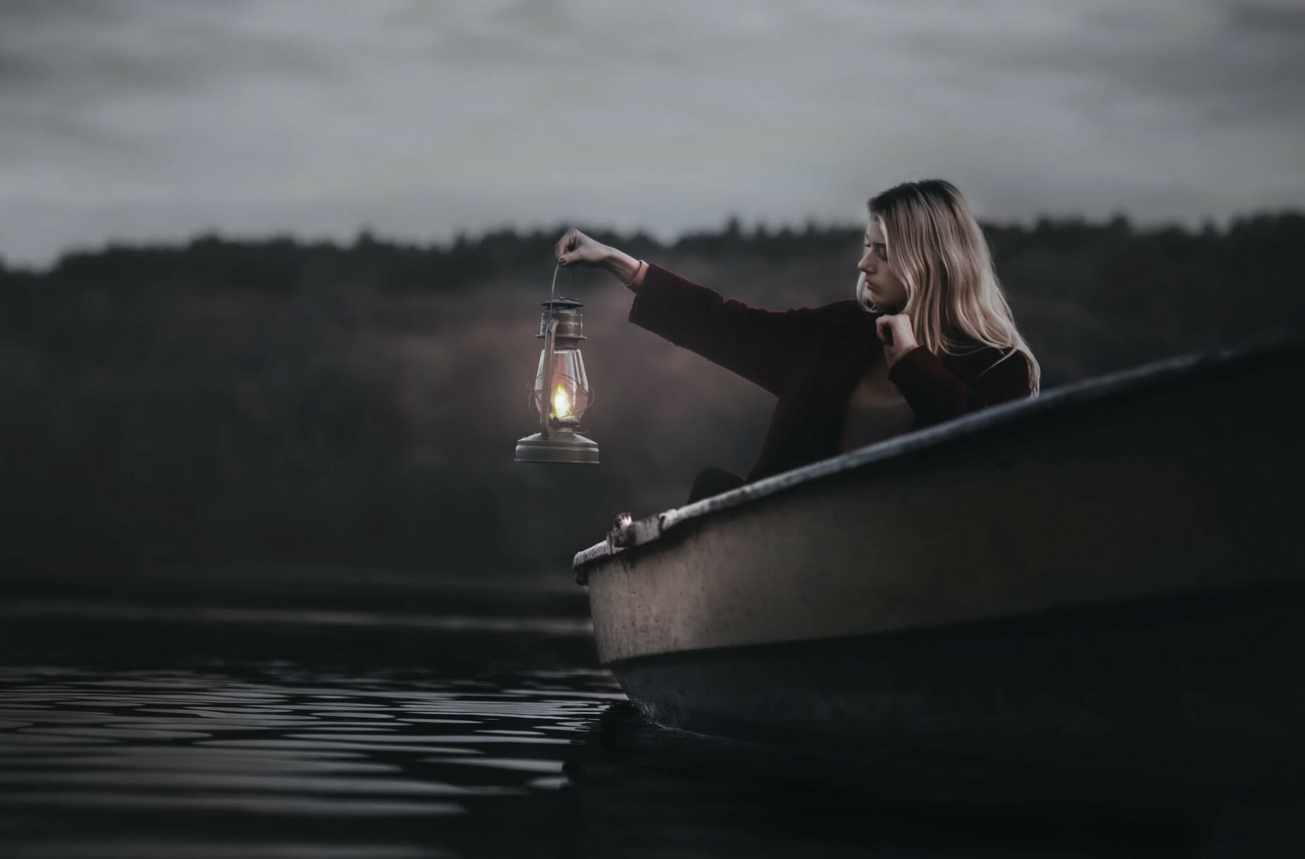 woman on a boat holding glass lantern