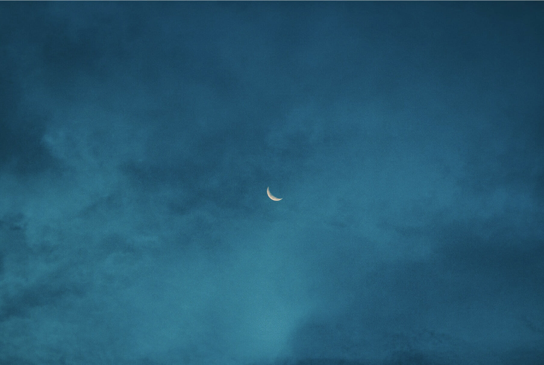 waning crescent moon on blue sky