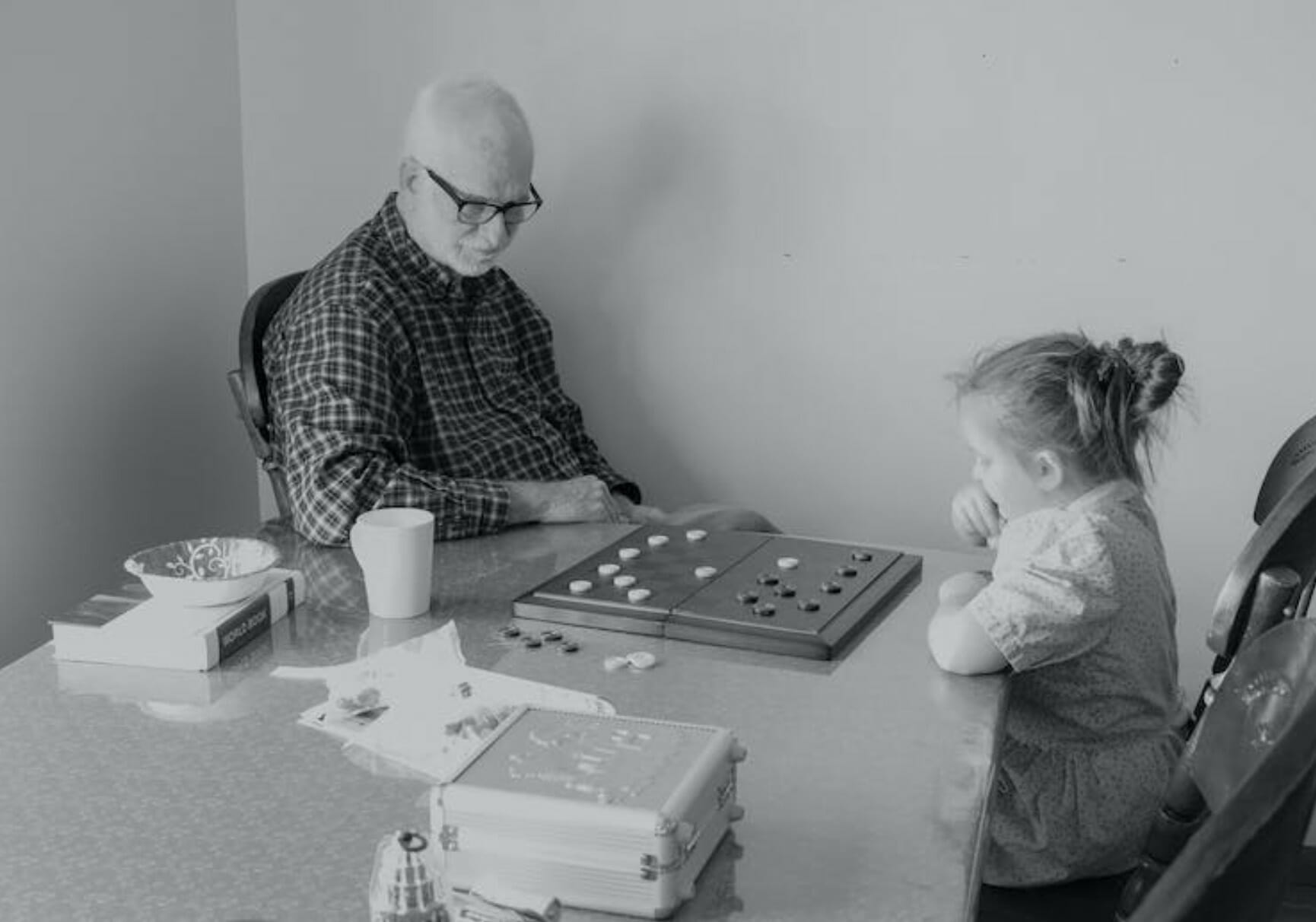 man and little girl playing checkers